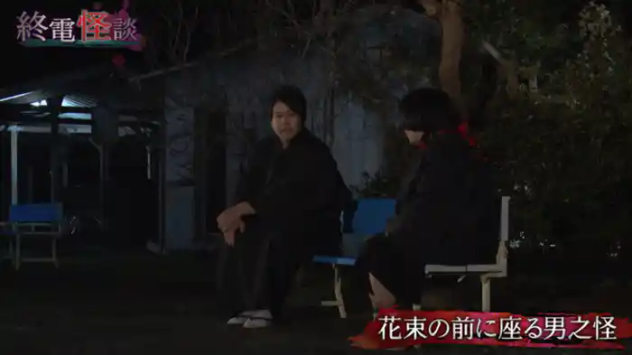 花束の前に座る男之怪